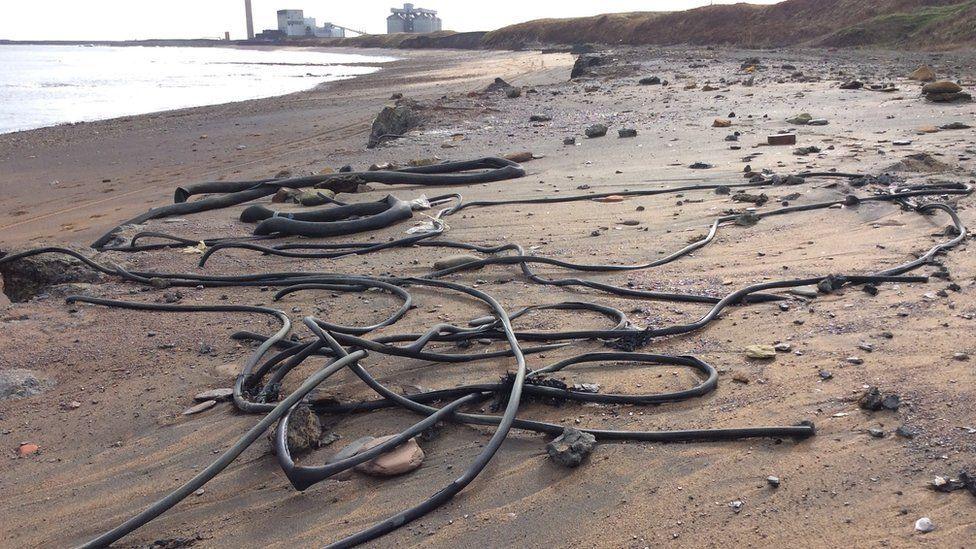 Pipes and cables on the sand at Lynemouth Beach.