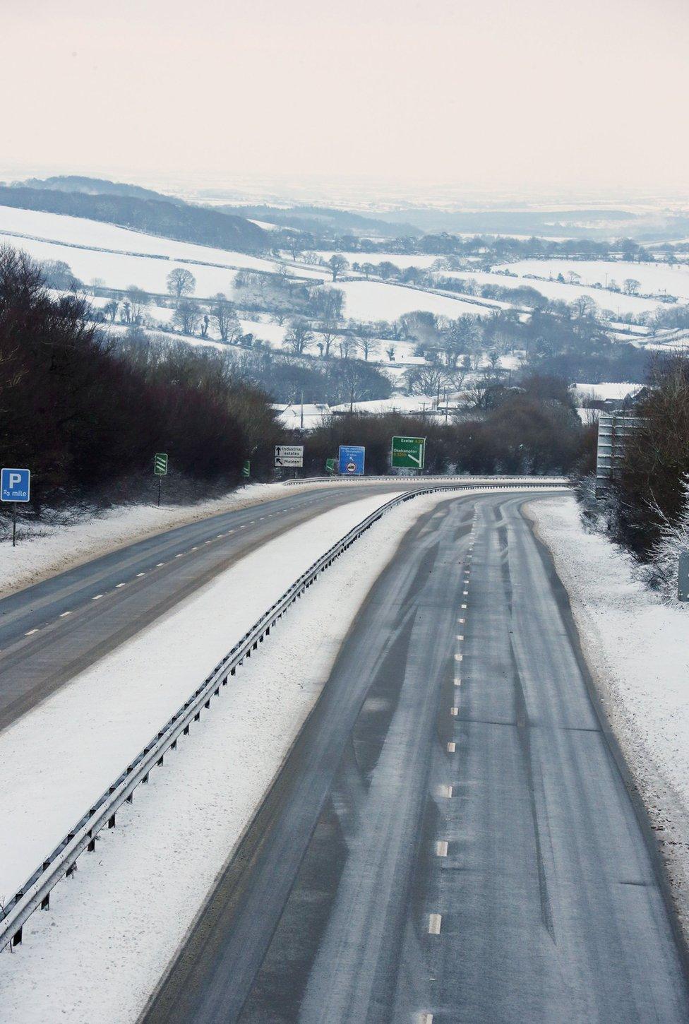 The A30 road seen empty with snow-covered hills seen in the background