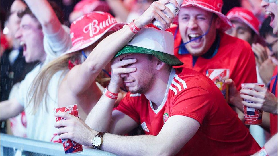 England fans celebrate next to a dejected Wales fan at the Budweiser Fan Festival London at Outernet, during a screening of the FIFA World Cup Group B match between Wales and England. Picture date: Tuesday November 29, 2022.