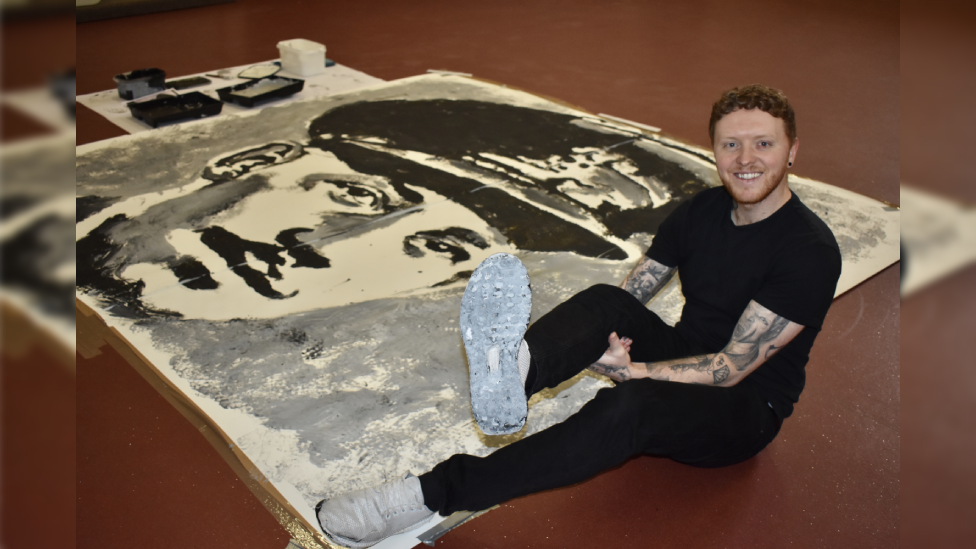 Nathan next to his painting of Captain Sir Tom Moore