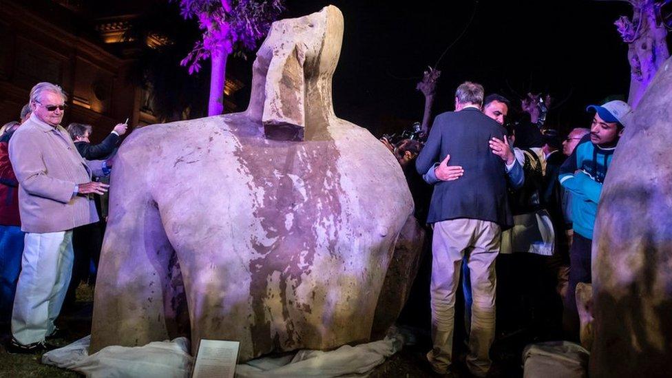 Denmark"s Prince Henrik (L) looks at the statue belonging to King Psamtik I, outside the Egyptian museum in Cairo on March 16, 2017