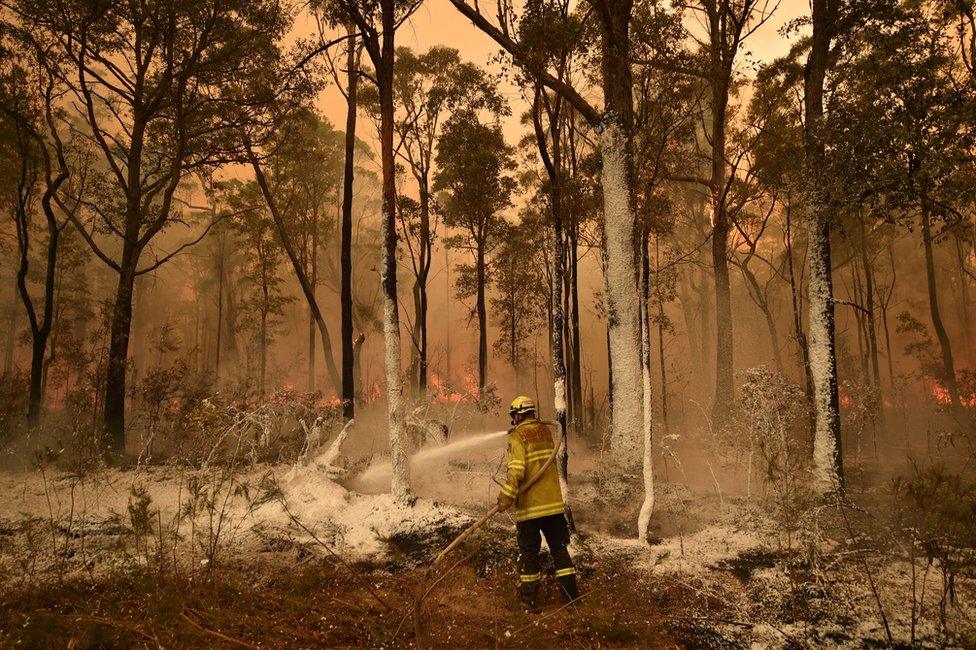 A firefighter sprays foam retardant