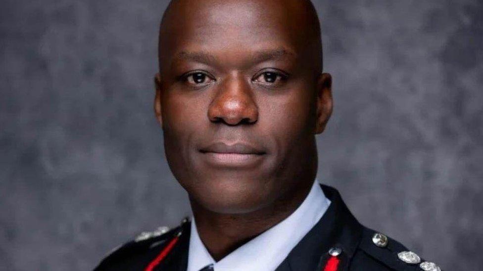 A man with a shaved head is looking at the camera. He is wearing a senior fire officer's uniform.