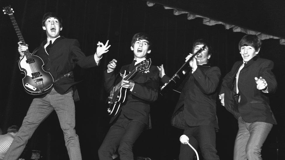 The Beatles jumping with their guitars