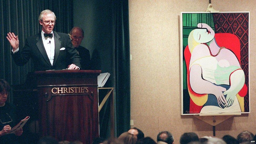 File picture taken 10 November 1997 shows Christopher Burge, chairman of Christie's (L), starting the bidding for Pablo Picasso's painting, 'Le Reve' in New York at an auction of the collection of Victor and Sally Ganz.