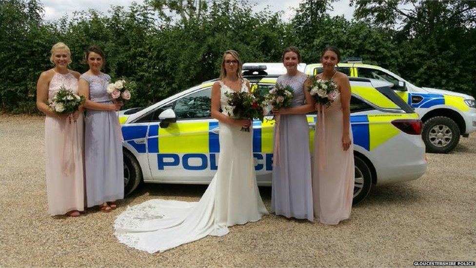 Bridal party posing by police cars