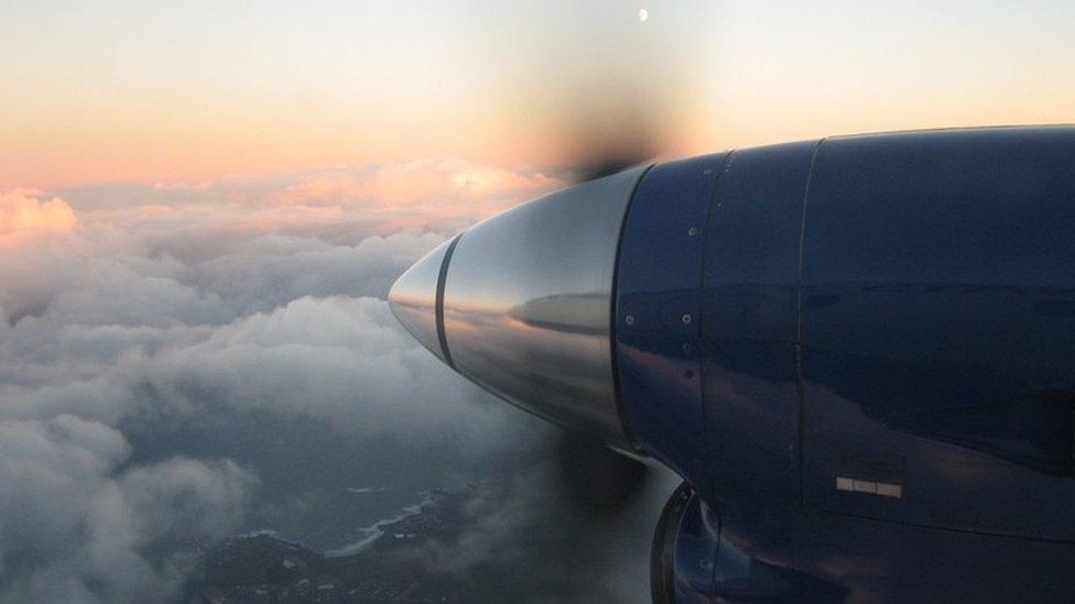 Loganair plane flying from the Shetland Islands to Aberdeen at sunset