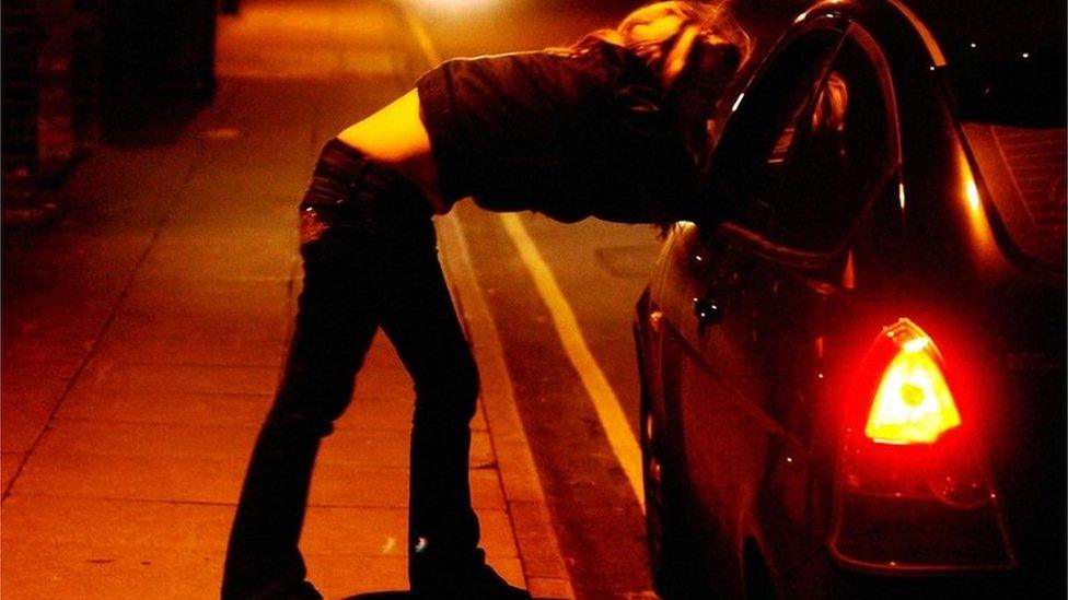 A girl talks to a driver through the car window