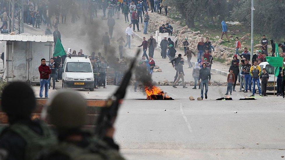 Palestinians and Israeli troops face each other in Hebron (file photo)