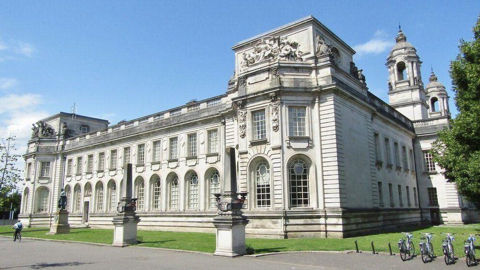 Cardiff Crown Court. A cyclist is riding past the grass outside the building