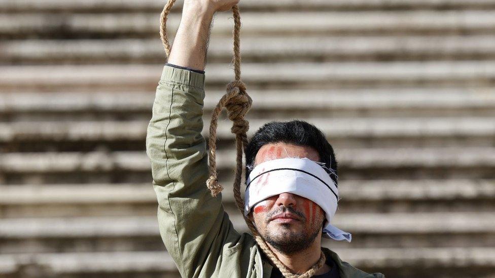 An Iranian-Portuguese man protests against the executions of two Iranian man in connection with the anti-government protests in Iran, in Lisbon, Portugal (16 December 2022)