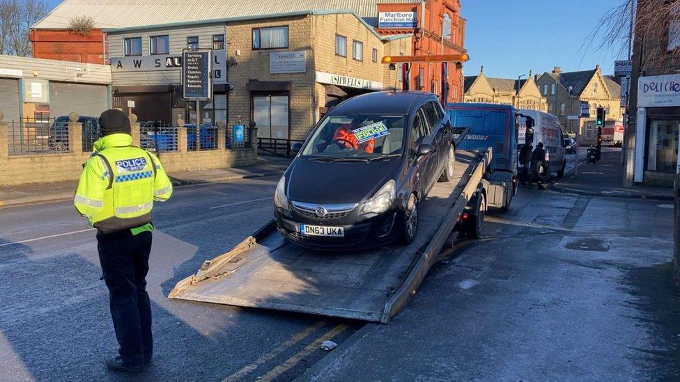 Seized car being loaded onto lorry in Bradford