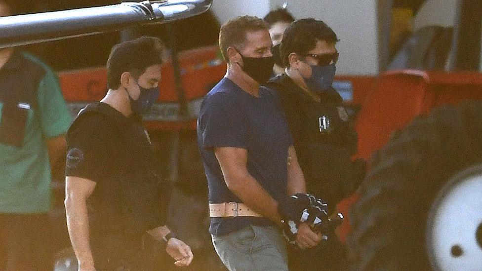 Rocco Morabito (c) being escorted off a plane in Brasilia