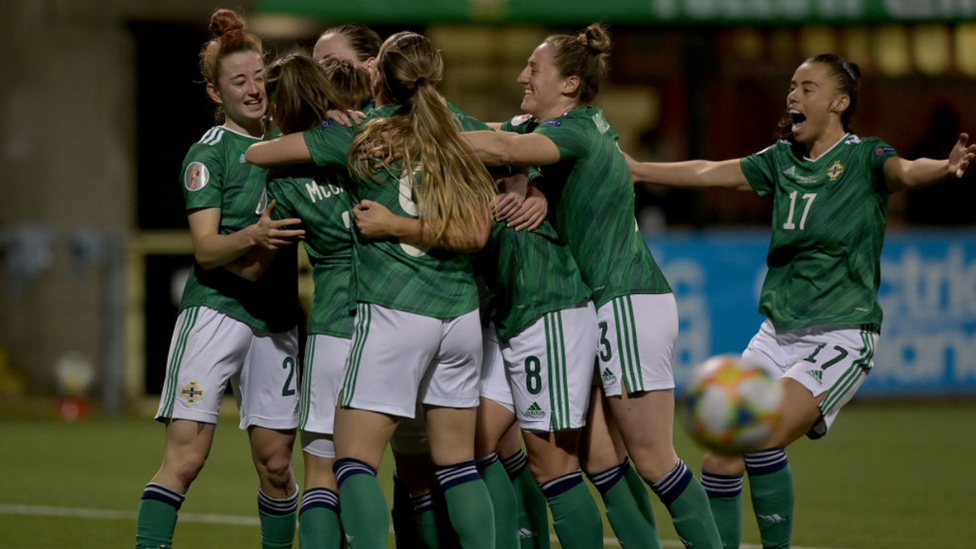 NI women's football team celebrate after scoring a goal