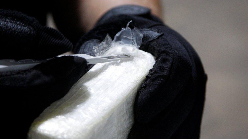 A file photo shows an agent cutting open a brick of cocaine seized by US Customs officials in June 2019