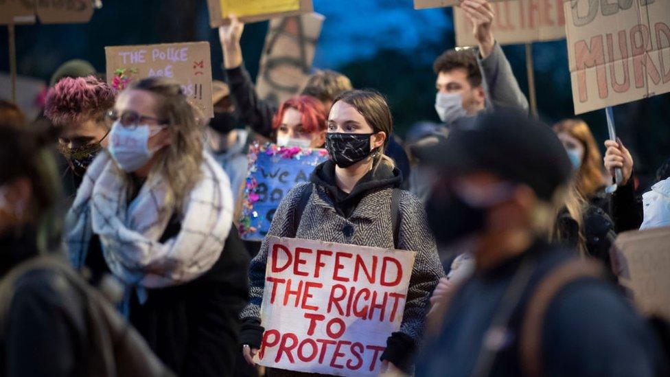 protestors hold signs