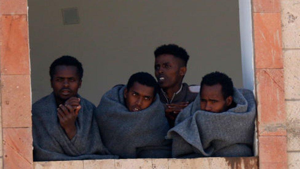 Ethiopian migrants are seen inside a building while undergoing quarantine as they across Yemen's land to reach Saudi Arabia