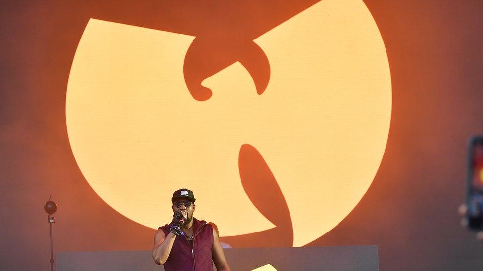 Picture of RZA in front of a Wu-Tang Clan symbol