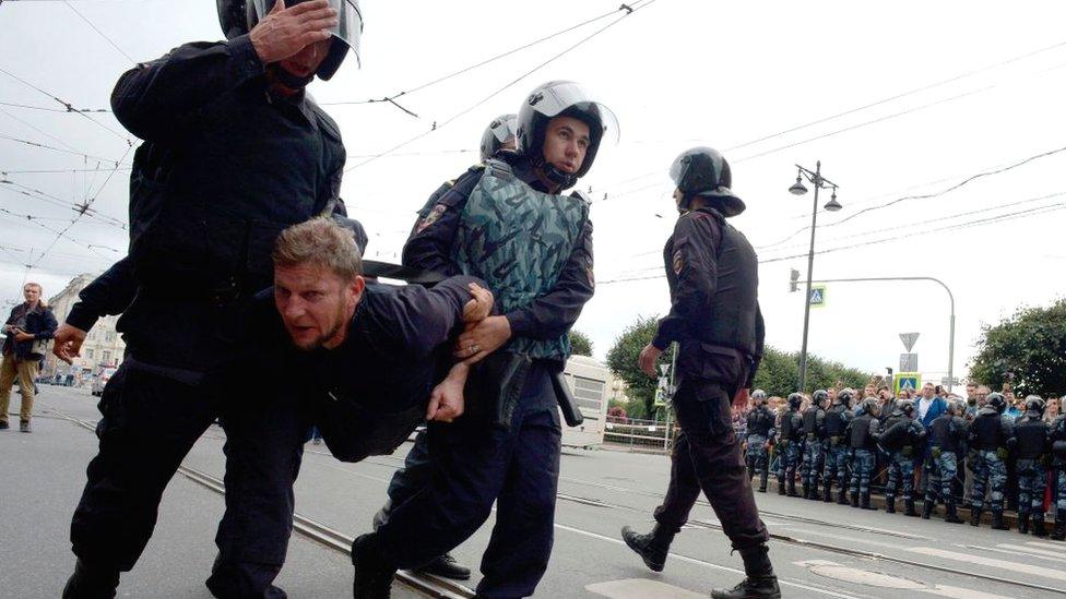 A protestor is carried away by police in St Petersburg