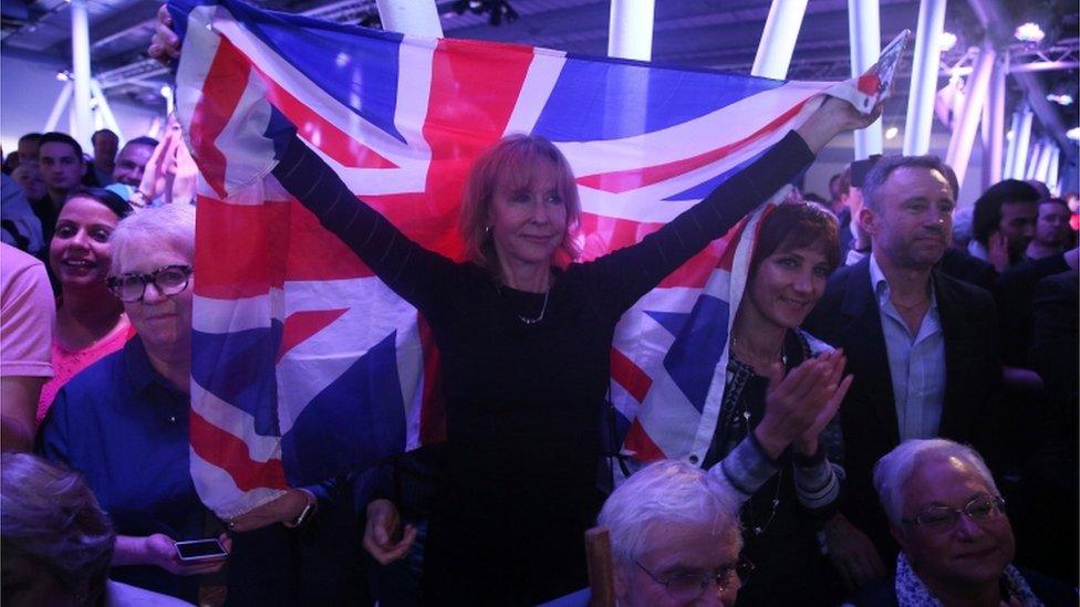 A Brexit supporter holds a Union Flag at a Vote Leave rally in London