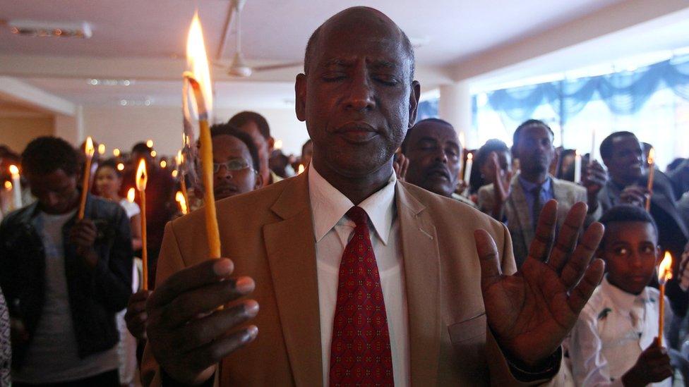 A man attends a prayer session during a candle and prayer ceremony for the demonstrators killed in the recent Oromo protest, in Ethiopia"s capital Addis Ababa, September 11, 2016