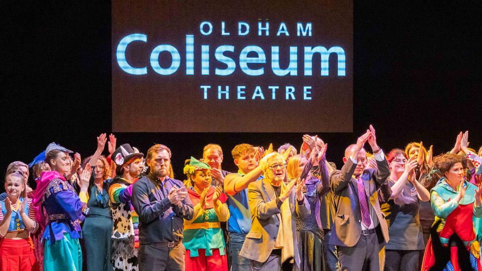 A crowd of performers gathered on the Oldham Coliseum stage in various costumes as the crowd applaud