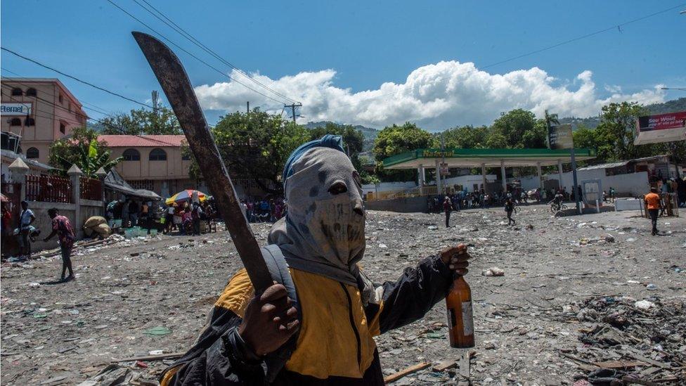 A person wearing a mask and holding a machete