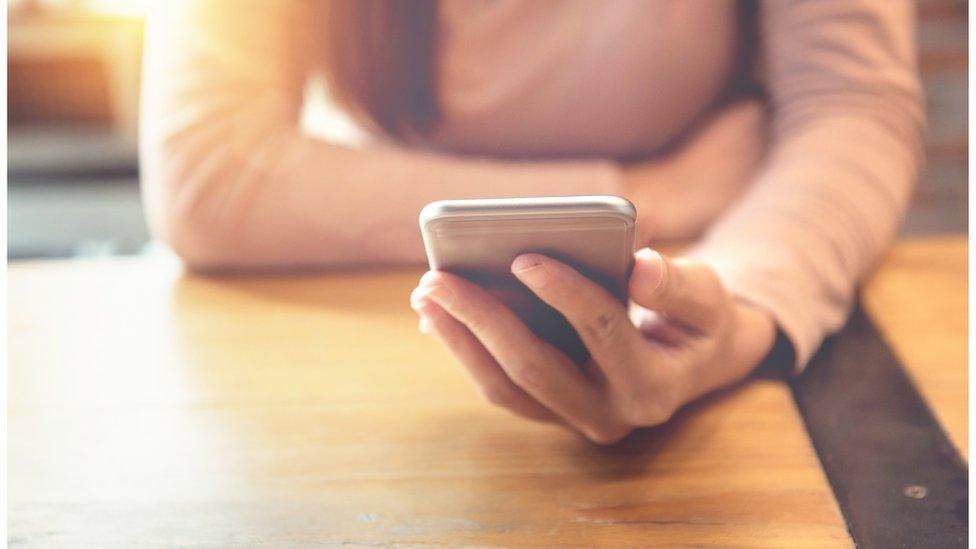 File photo of a woman holding a phone