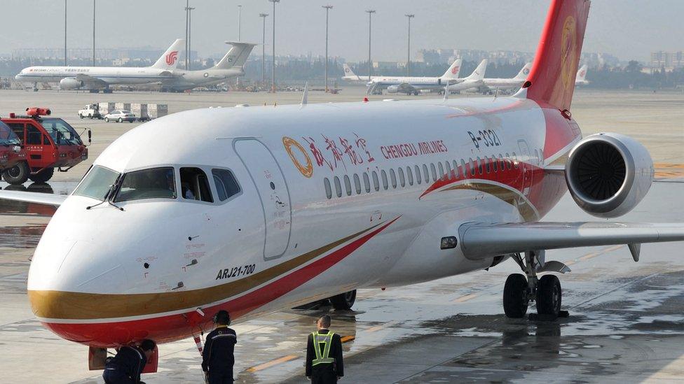 Chengdu Airlines crew members celebrate the arrival of the ARJ21 jet at the Shuangliu International Airport on 29 November 2015