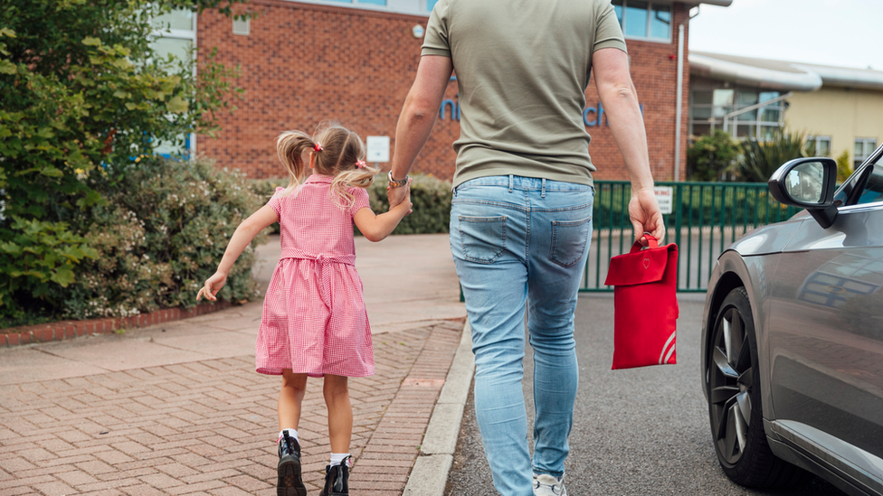 Parent with child at school gates