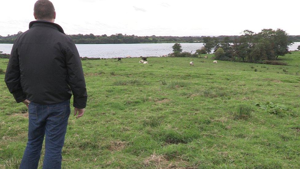 Farmer Simon Donnelly looks out over his field near Lough Neagh