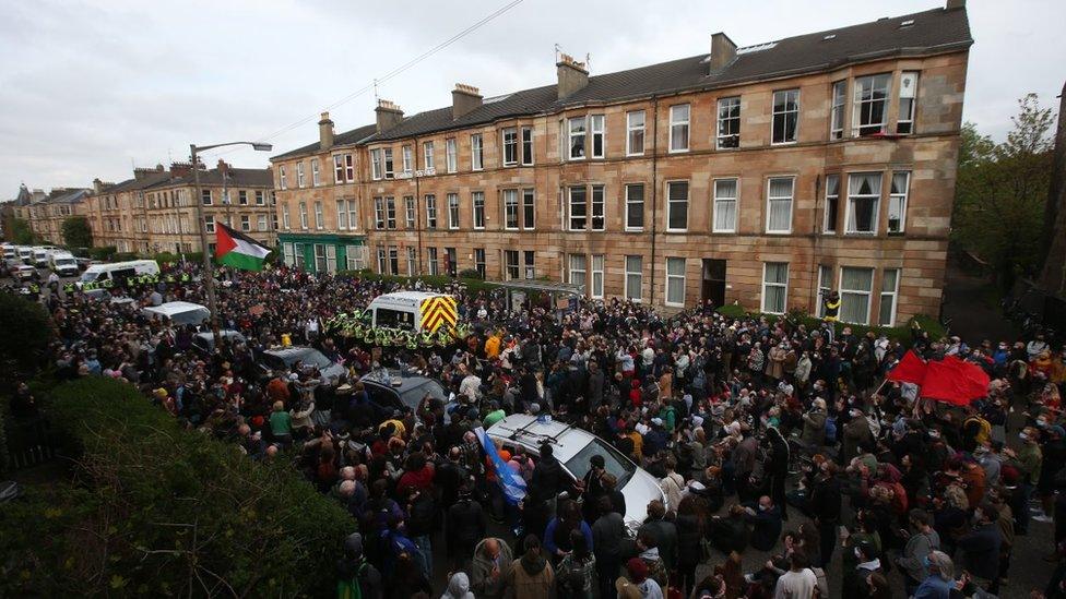 Police by an immigration van in Kenmure Street, Glasgow which is surrounded by protesters. Picture date: Thursday May 13, 2021.