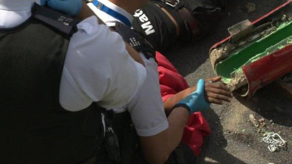 Police free protesters arms form tubes filled with concrete