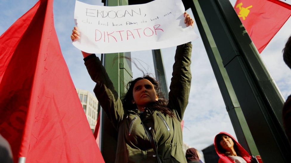 A protester holds a banner reading "Erdogan, you are not a leader, you are a dictator" during a demonstration in Berlin, 28 September 2018