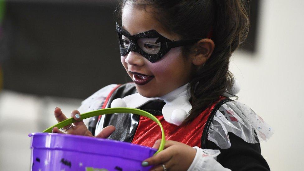 A young girl trick or treating