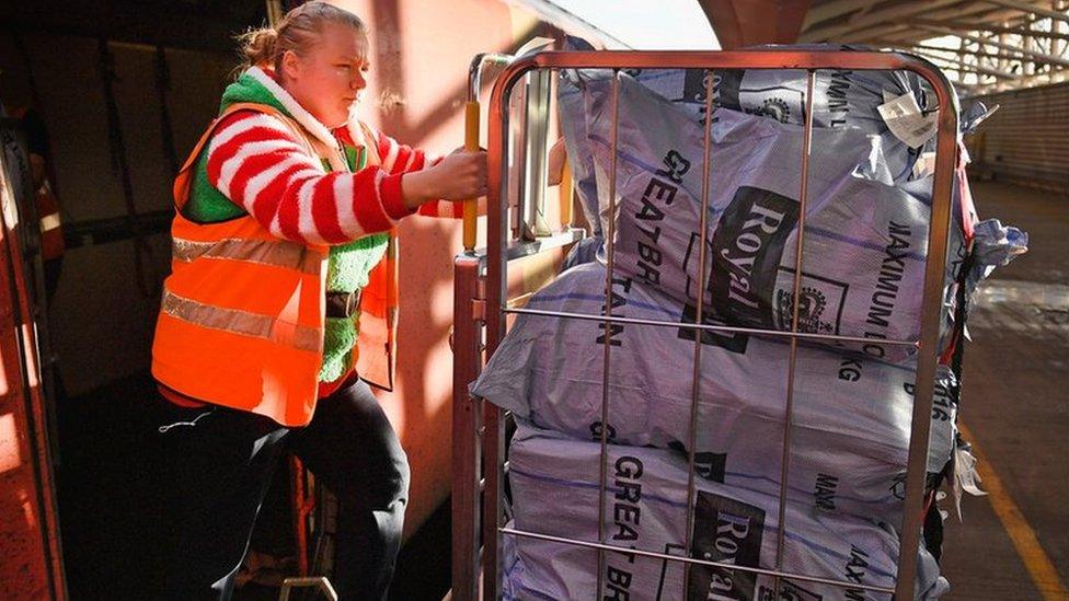 A Royal Mail train is unloaded by a worker at the Scottish Distribution Centre before travelling south