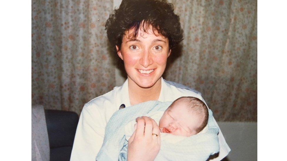 Ben pictured as a baby with midwife Jude