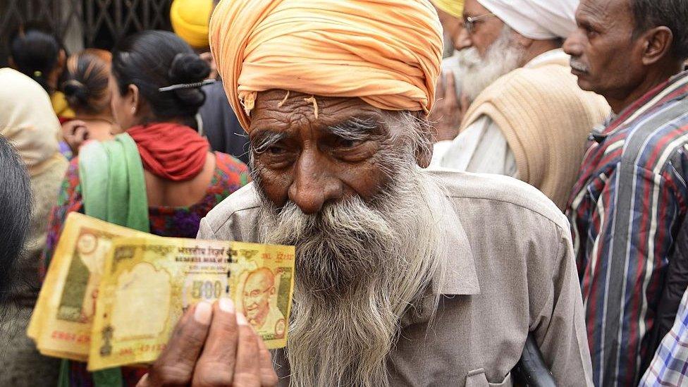 Man waits outside a bank to deposit and exchange 500 and 1000 rupee notes in Amritsar, India, in November 2016.