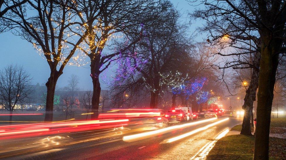 cars at dusk with christmas lights