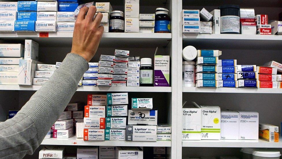 an arm reaching for medication on shelves