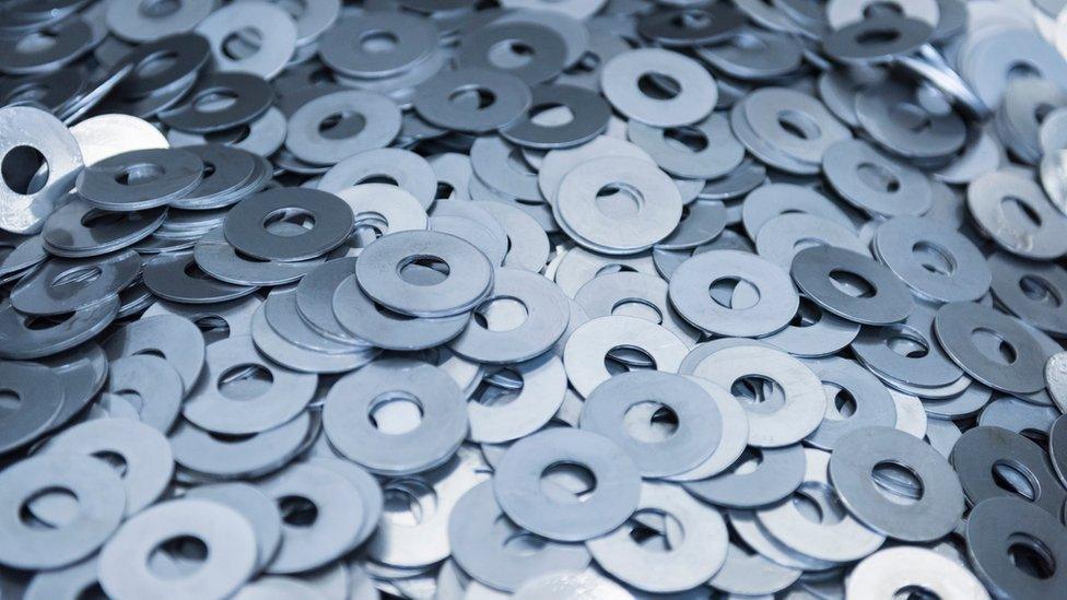 Cut metal washers in engineering factory, close up - stock photo