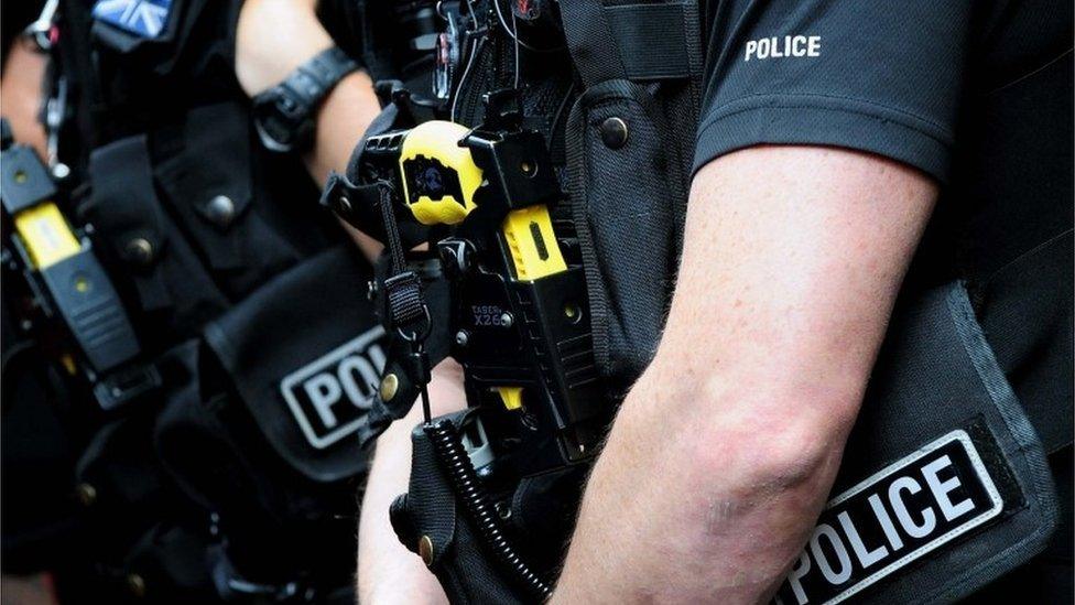 Close up picture of an officer carrying a Taser