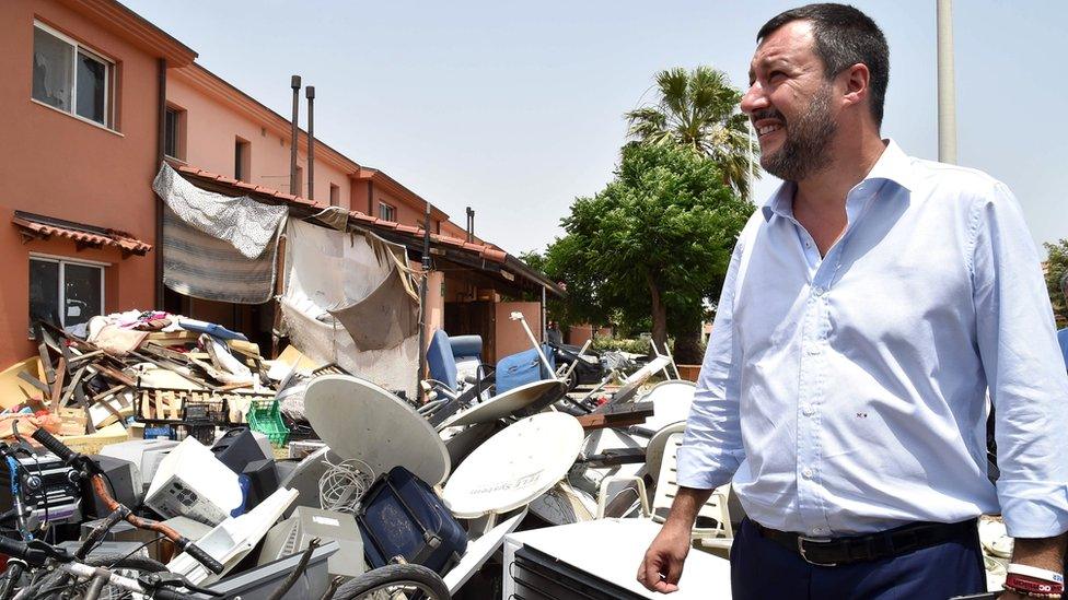 Matteo Salvini stands by a pile of rubbish as he tours the Mineo migrant centre, 9 July 2019