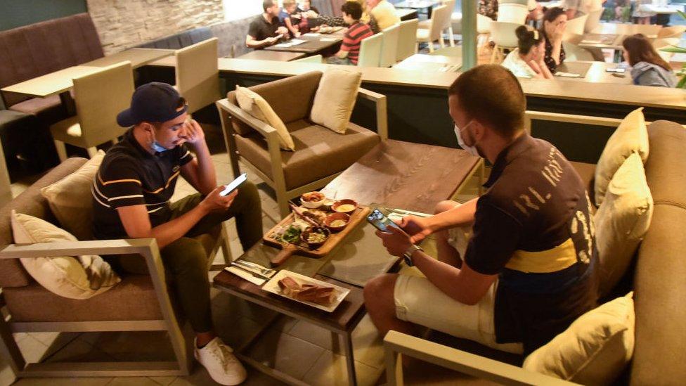 Customers wear protective face masks against the novel coronavirus at a restaurant in Algiers, on August 19, 2020