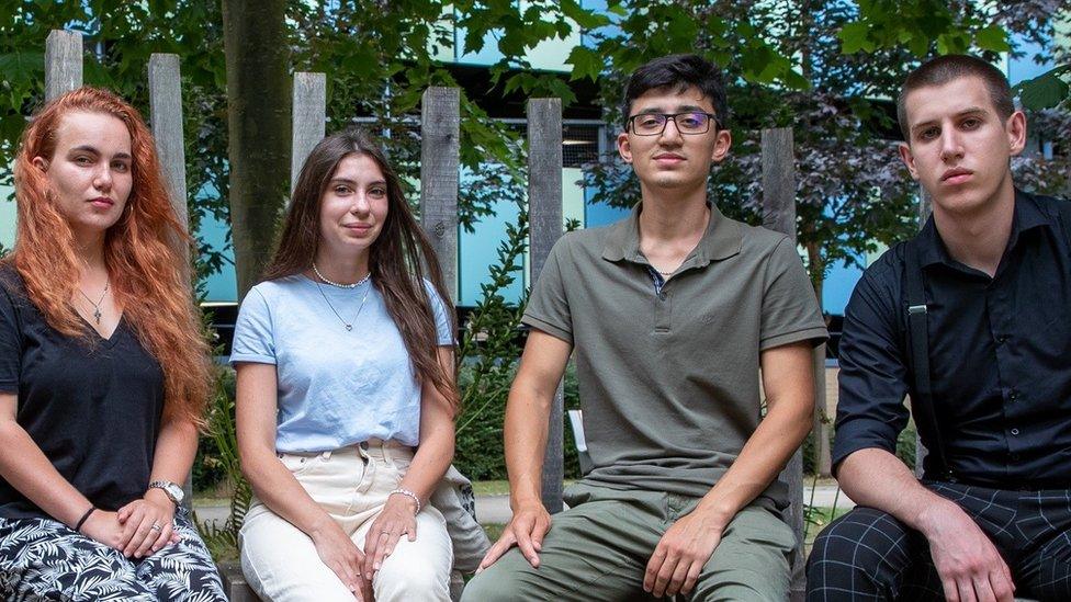 Vira Lavryk, Kateryna Ausheva, Zaur Badalov, Serhii Alkhimov sitting on a bench at the University of Cambridge