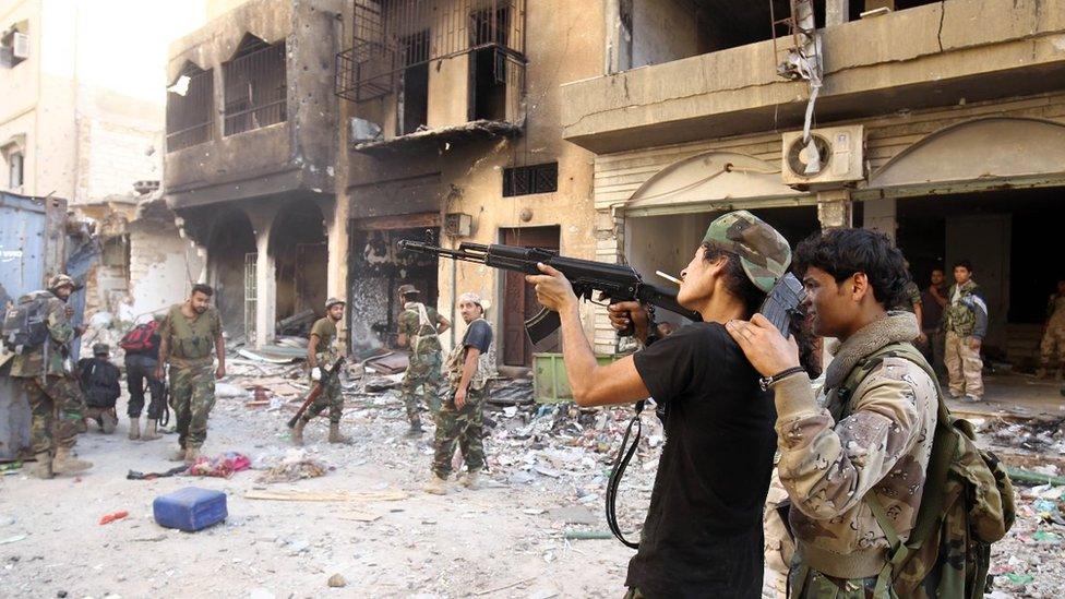 Members of the self-styled Libyan National Army, loyal to the country's east strongman Khalifa Haftar, practice firing a Kalashnikov assault rifle as they rest following clashes with militants in Benghazi's central Akhribish district on November 9, 2017.