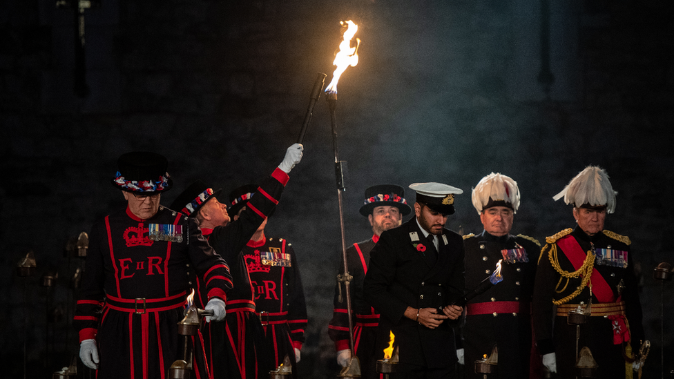 The first torch is lit in a ceremony to mark armistice day at the Tower of London