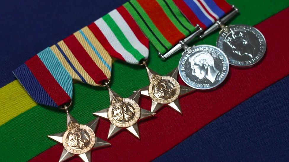 The war medals - three gold stars and two silver coins on multicoloured ribbons