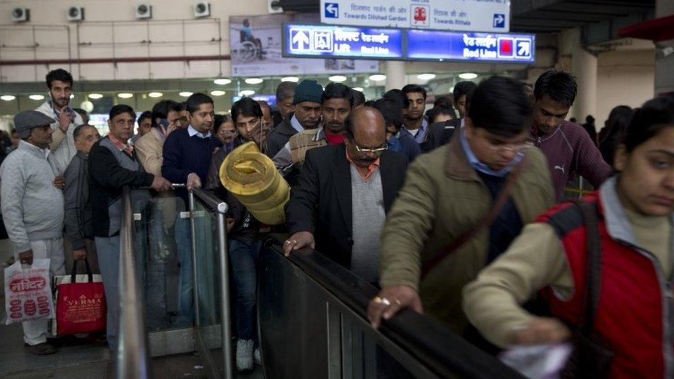 Indians wait to enter a subway station as they use public transport during a two-week experiment to reduce the number of cars to fight pollution in New Delhi, India, Monday, Jan. 4, 2016.