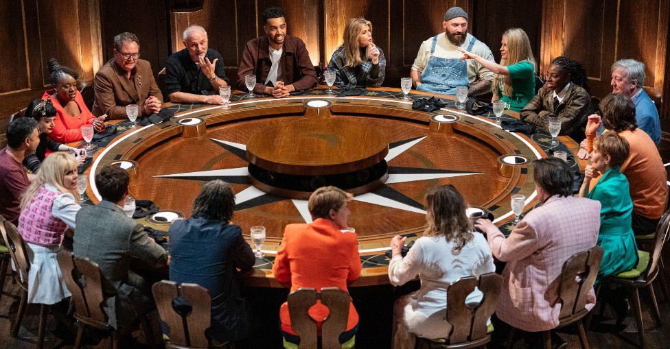 The celebrity contestants sitting at the round table